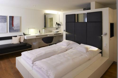 a bedroom with a large white bed and a sink at Zollhaus - Doppelzimmer in Endingen