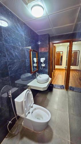 a bathroom with a white toilet and a sink at Viet Son Lam Hotel in Dồng Văn