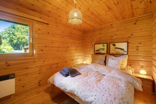 a bedroom with a bed in a wooden cabin at Ferienhaus 'Albblick' in Starzach