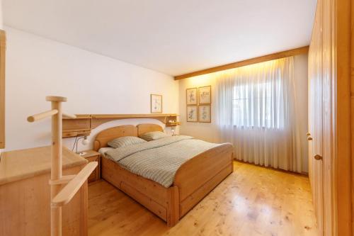 a bedroom with a wooden bed and a staircase at Apartment Kreutnerbinderhof in Terlano