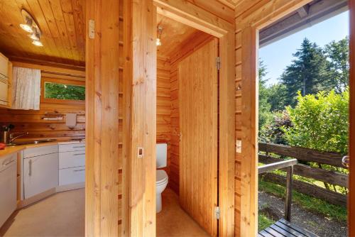 a log cabin bathroom with a toilet and a large window at Ferienhaus 'Albblick' in Starzach