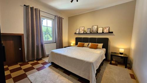 a bedroom with a large bed and a window at Apartments am Saalebogen mit Gartenterrasse, Grillkamin und freie Parkplätze in Rudolstadt