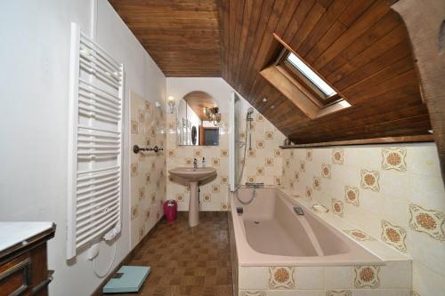a bathroom with a bath tub and a sink at La maison Bayle in Mauvezin