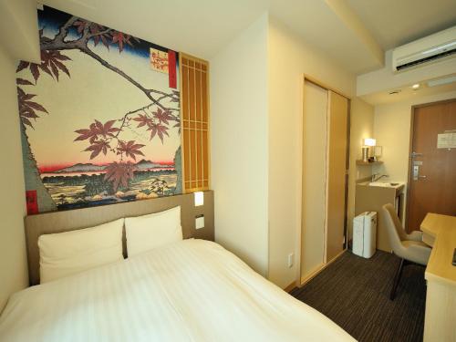 a bedroom with a bed and a painting on the wall at Dormy Inn Akihabara in Tokyo
