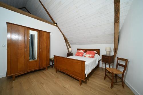 a bedroom with a bed and a table and a chair at La maison Bayle in Mauvezin