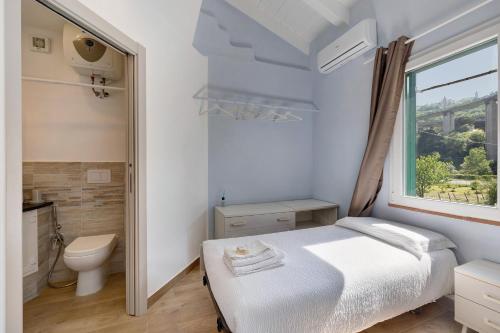 a bedroom with a bed and a toilet and a window at Ca di Perti Apt 3 in Finale Ligure