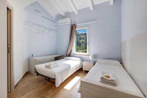 a bedroom with two beds and a window at Ca di Perti Apt 3 in Finale Ligure