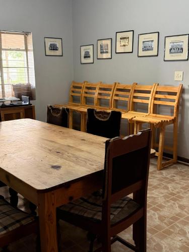 a dining room with a wooden table and chairs at Venterspoort Farmhouse in Philipstown