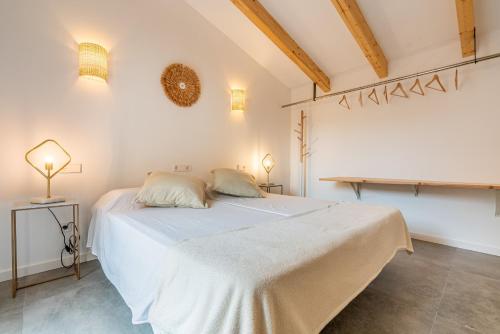 a bedroom with a white bed and two lamps at Cas Suis 9 in Campanet