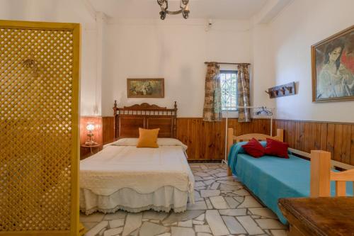 a bedroom with two beds and a table and a window at Casa Encarnacion in Granada