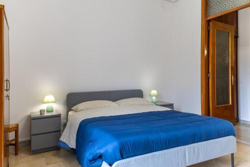 a bedroom with a bed with a blue bedspread at Pollicita 80 in Chiaramonte Gulfi