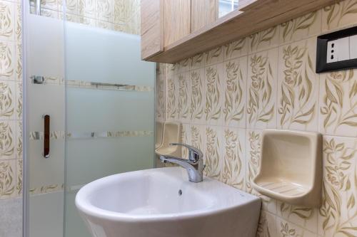 a bathroom with a sink and a urinal on the wall at Pollicita 80 in Chiaramonte Gulfi