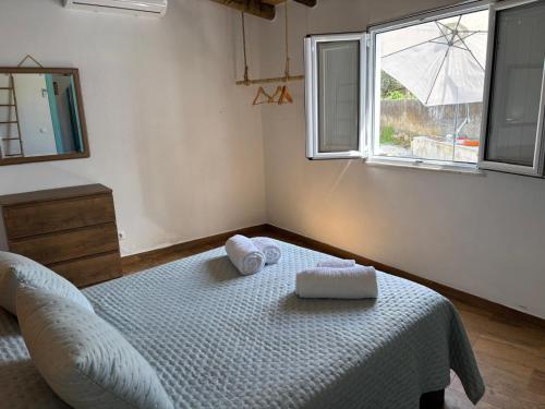 a bedroom with a bed with two towels on it at Casa do Aguadeiro in São Marcos do Campo
