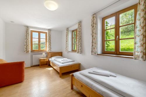 a bedroom with two beds and two windows at Zweilindenhof in Seeshaupt