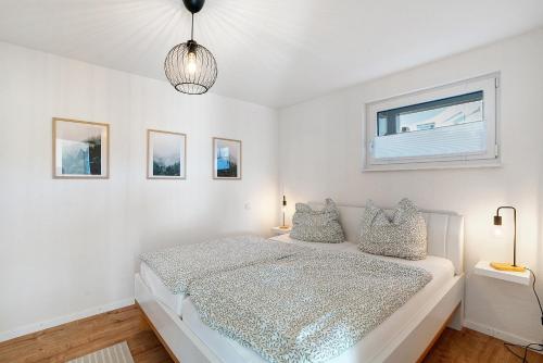a white bedroom with a bed and a window at Ferienwohnung am Tanzberg in Oberkirch
