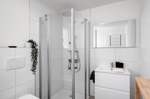 a white bathroom with a shower and a sink at Ferienwohnung am Tanzberg in Oberkirch