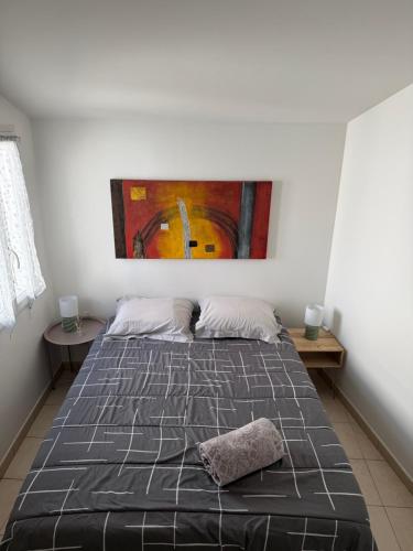 a bedroom with a bed with a painting on the wall at L'échoppe Rochelaise in La Rochelle