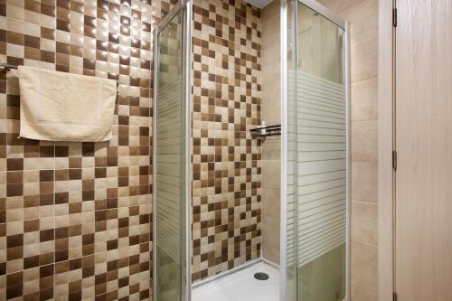 a shower with a glass door in a bathroom at Casa Ribeiro Alojamento Local in São Martinho do Porto