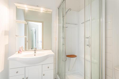 a white bathroom with a sink and a shower at Maison d'hôtes Le Grillon in La Brée-les-Bains