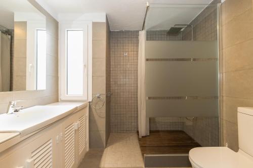 a bathroom with a shower and a sink and a toilet at Ca Sa Mola in Cala Santandria
