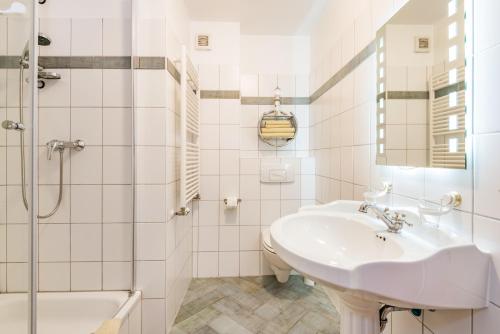 a white bathroom with a sink and a shower at Aquarius Ferienwohnung Usedom in Loddin