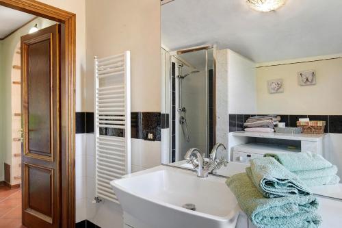 a white bathroom with a sink and a mirror at Emma e Adele House in Marlia