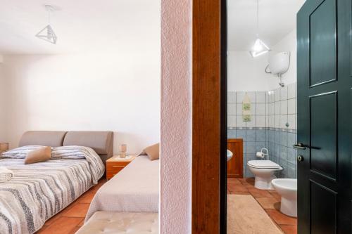 a bedroom with two beds and a bathroom with a toilet at Vistamare2 in Cardedu