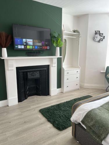 a living room with a fireplace with a flat screen tv at 1st Floor 1 Bed Studio in Weston-super-Mare