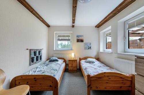 two beds in a room with two windows at Ferienhof Littmann in Friedrich-Wilhelm-Lübke-Koog