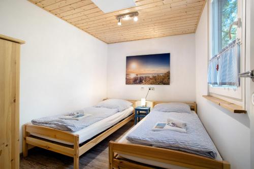 two twin beds in a room with a window at Bungalow Hörselberg, Bgl 15 in Dranske