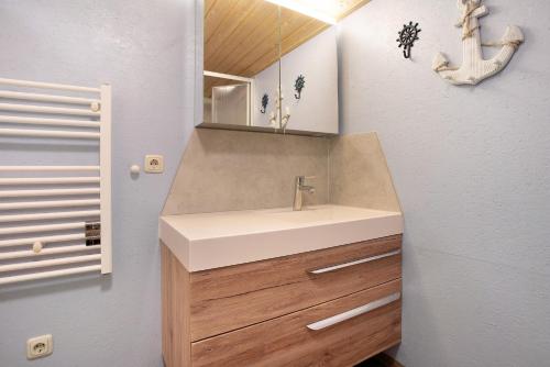 a bathroom with a sink and a mirror at Bungalow Hörselberg, Bgl 15 in Dranske