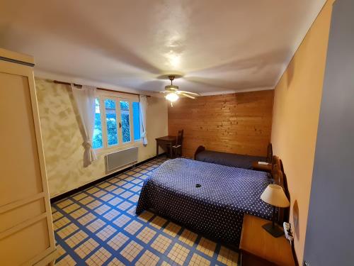 a bedroom with a blue bed and a window at Gîte du Poney Fringant in Saint-Paul-Trois-Châteaux