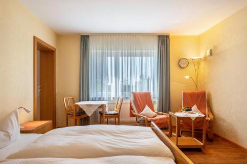 a hotel room with a bed and a table and chairs at Haus Gramespacher in Bad Bellingen