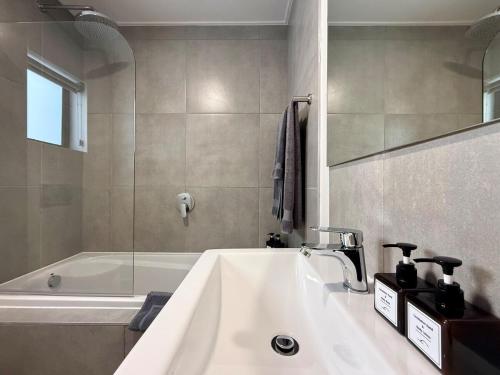 a bathroom with a sink and a bath tub at Indigo Tide - Mossel Cove Unit 201 in Mossel Bay