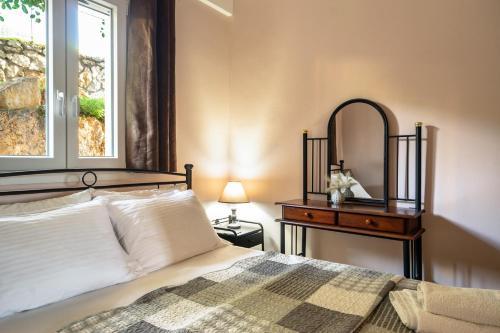 a bedroom with a bed and a table with a mirror at Zoi studio in Kefallonia