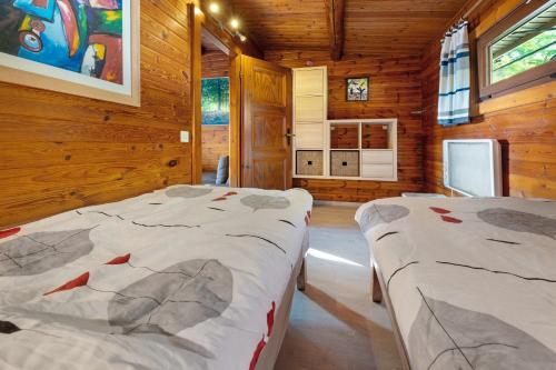 two beds in a room with wooden walls at Haus-am-Harz Bad Gandersheim in Bad Gandersheim