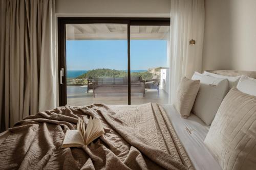 a bedroom with a bed and a view of the ocean at Sunset Dream Luxury Villa in Keri