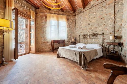 a bedroom with a bed in a room with stone walls at Casa Encanto con Jacuzzi in Montroig