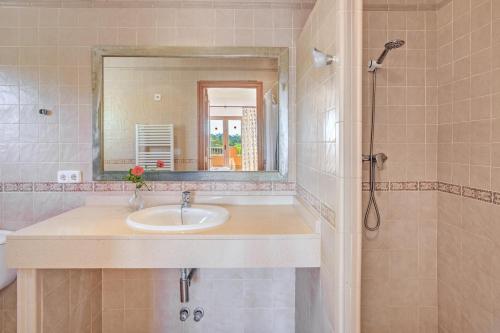 a bathroom with a sink and a mirror and a shower at Villa Luis Vives in Port de Pollensa