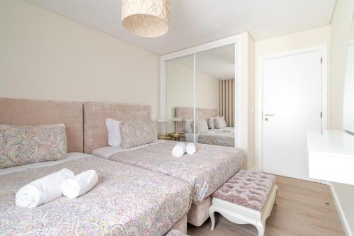 a bedroom with two beds and a mirror at Surf and Chill House in Viana do Castelo