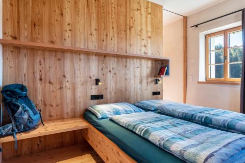 a bedroom with wooden walls and a bed with a backpack at Hof im Thal Apt Lärche in Aldino