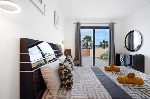 a bedroom with a bed with a view of the ocean at Recanto Dourado in Porto Santo