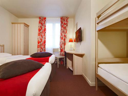 Una habitación de hotel con dos camas y una ventana. en Campanile Val de France, en Magny-le-Hongre