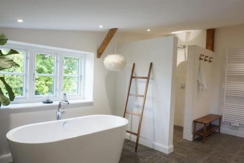 a bathroom with a white tub and a window at Der Mühlenhof in Högel