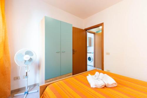 a bedroom with a bed with a fan and white towels at Appartamenti Cavour cod C in Villasimius