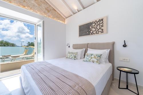 a bedroom with a bed and a large window at The Olive Yard Corfu Sidari in Karousádes