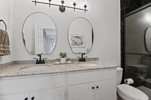 a bathroom with two sinks and two mirrors at Red Bluff Cottage in Montgomery