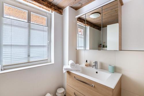 a bathroom with a sink and a mirror at Jules Reetdachkate in Mildstedt