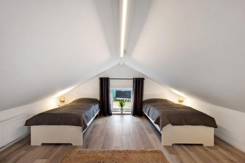 two beds in a attic bedroom with white walls at Küsten-Bude in Elmenhorst