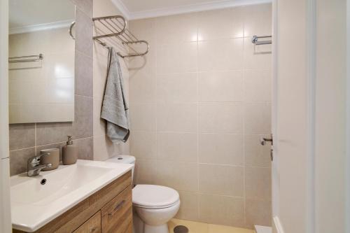 a bathroom with a toilet and a sink at Telmus Villa 1 andar in Monte Gordo